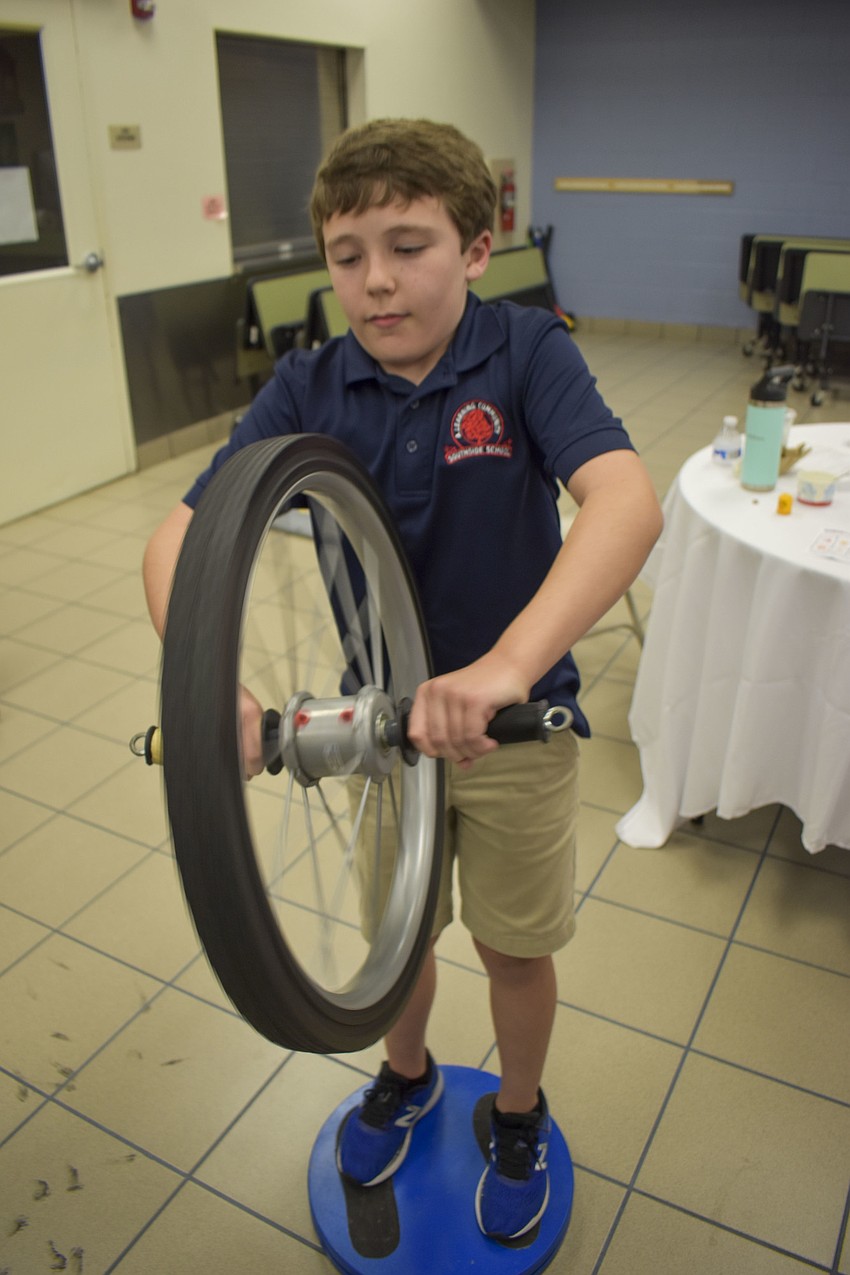 Tyler Paul, 10, uses a gyroscope to spin on a moving base.
