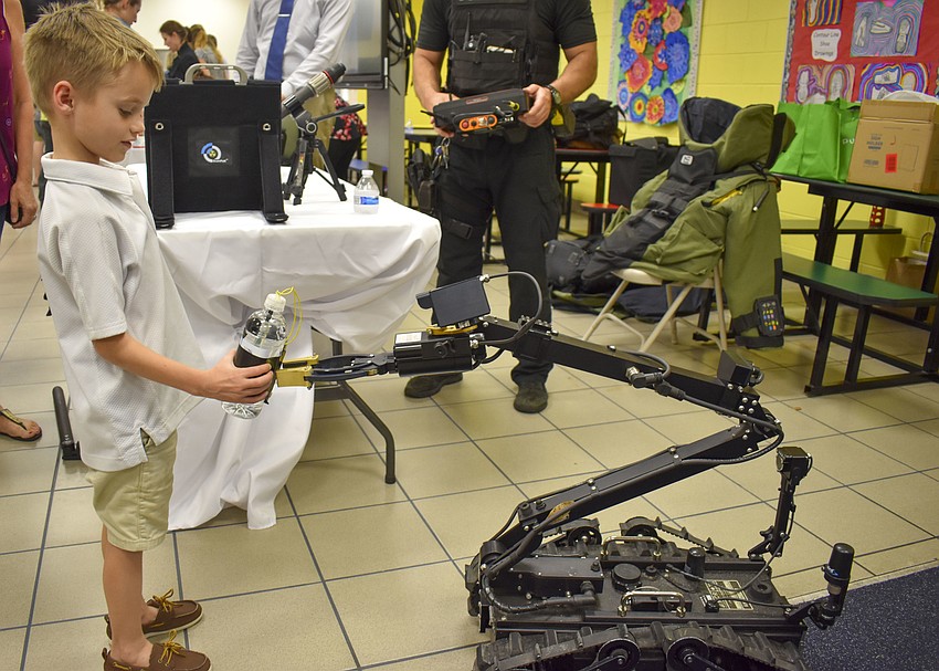 William Johnson, 6, plays with the police department robot.