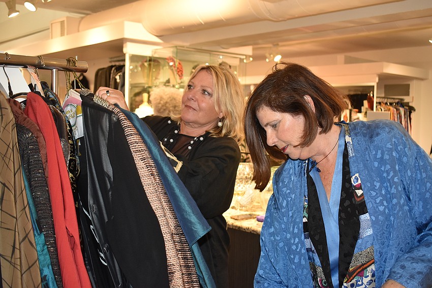 Joan Morgan and Rebecca Sachs look through a rack of vintage pieces.