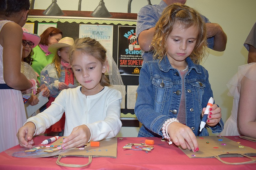 Lily Fouche, a kindergartner, does a craft alongside her sister, Madelyne, a second grader.