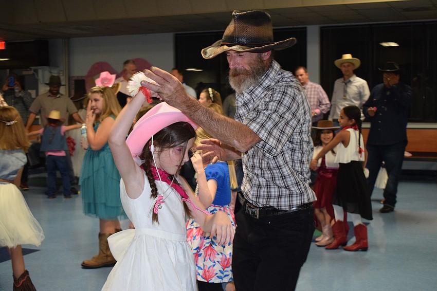 Emalie Roberts, a third grader, goes to the dance every year with her father, Eugene. Eugene Roberts likes the western theme because he thinks it's easier to dance to country music.