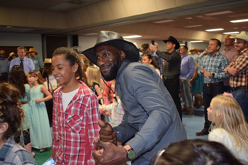 Naomi Cummings, a fourth grader, and her dad, Errol Bryant, dance to the 