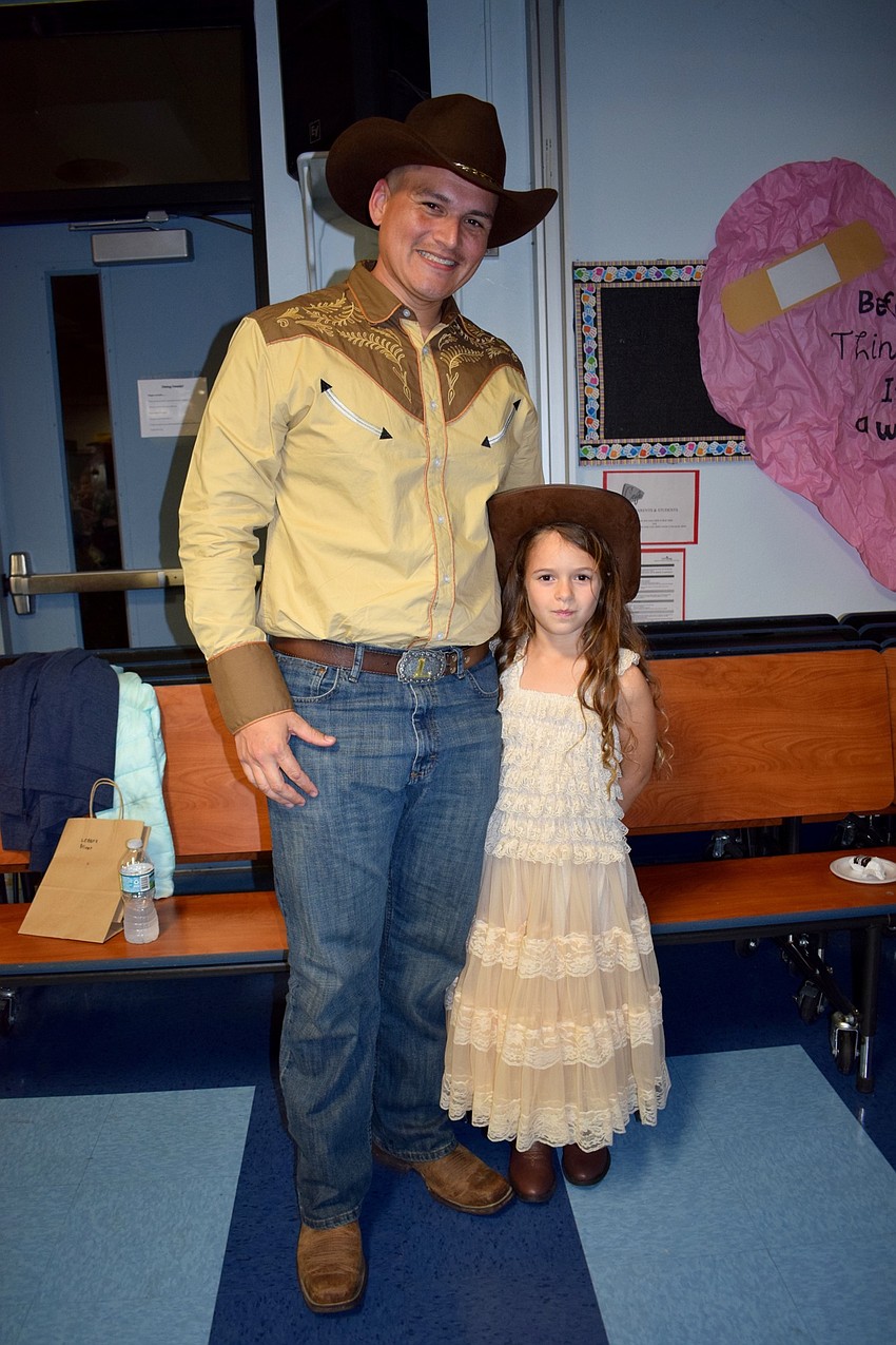 Oscar Lucin and his daughter Adelyn, a second grader, dress all-out for the Old Time Road theme of the dance. 
