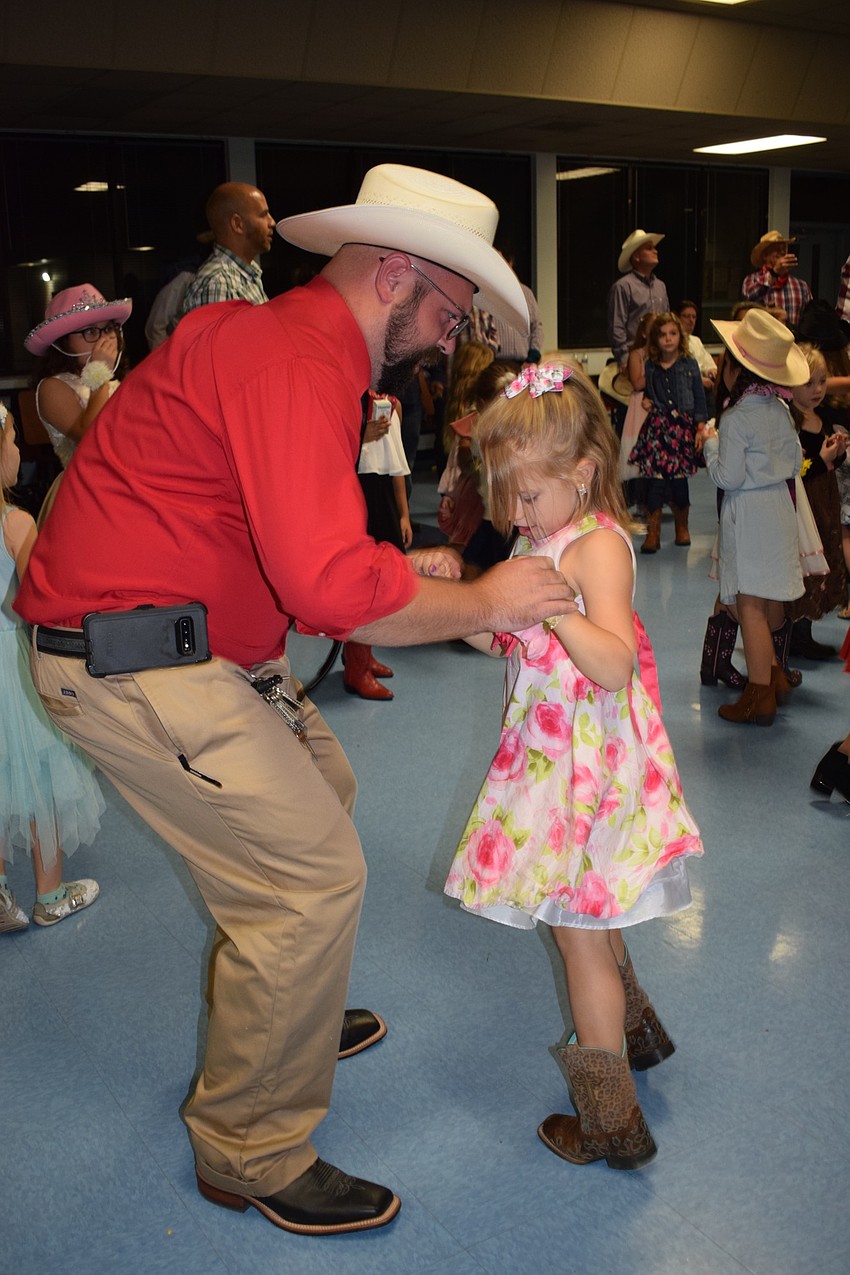 Andrew Cerquozzi twists while dancing with his daughter Marley, a kindergartner. This year was the first father-daughter dance for the Cerquozzis. They both love playing the games available.