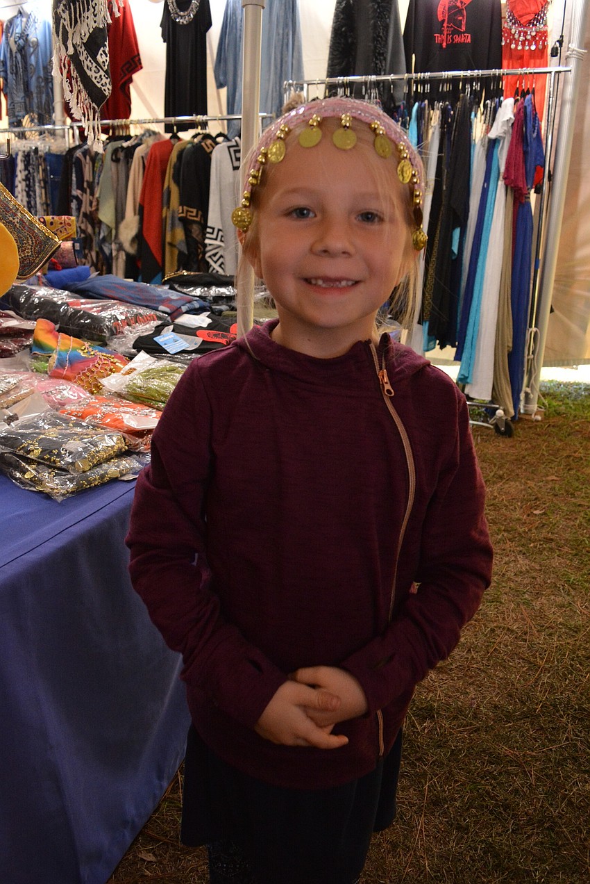Six-year-old Abigail Hartley tries on a head wreath.
