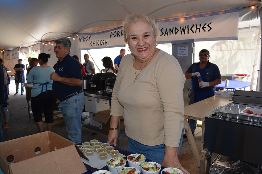Myakka City's Helen Birakis enjoys listening to the Hellenic music as she volunteers on the food line.