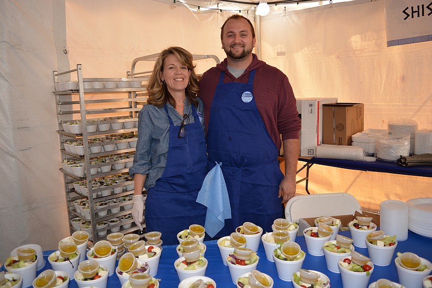 Two-year volunteer Irene Nikitopoulos, of Mill Creek, and six-year volunteer Tristan Welch, of Bradenton, serve Greek salads.