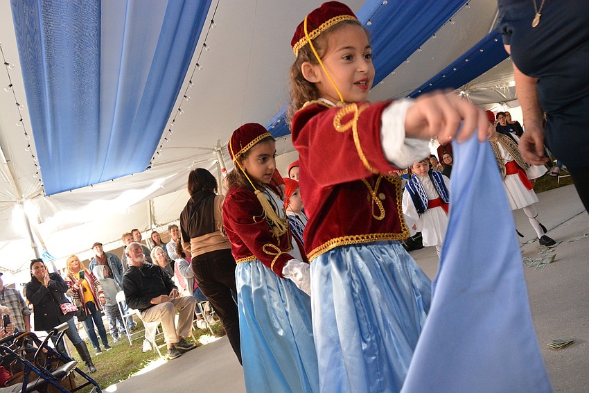 Emilia Nicolaides is all smiles as she takes the lead for a group of Hellenic dancers.