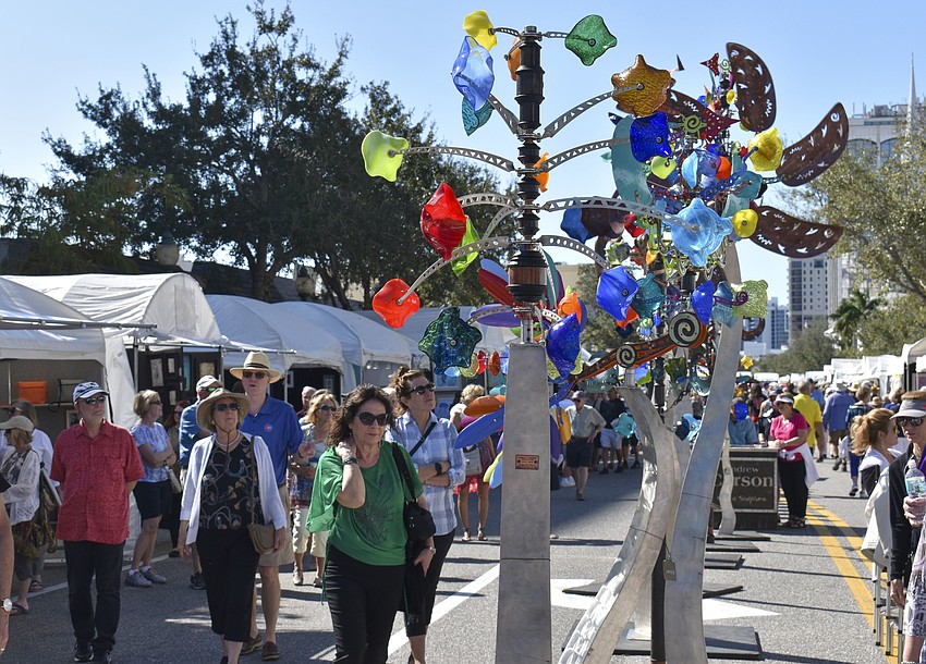 People stop to look at the metal sculptures by Andrew Carson