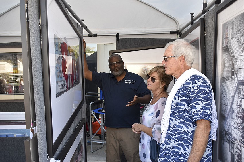 Photographer Timothy Hall explains one of his pieces to Tracey and Tom Frascone.