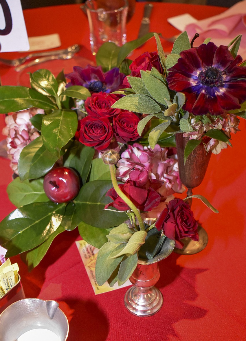 Red and pink flowers sit on each table.