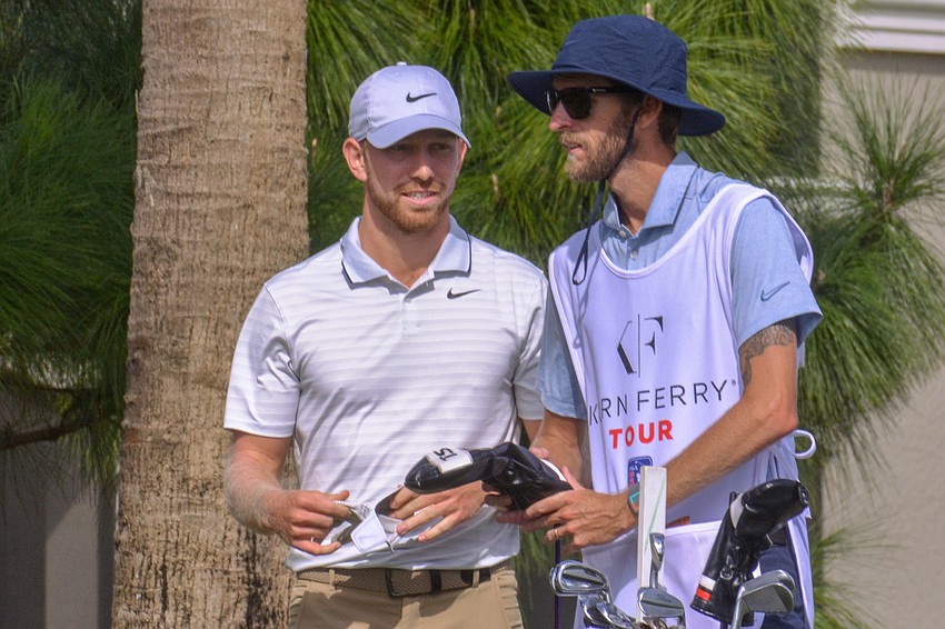 Jimmy Stanger, from Tampa, chats with his caddie after his tee shot on the No. 1 hole at the LECOM Suncoast Classic.