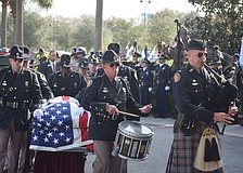 A bagpiper and a drummer lead the coffin of Trooper Joseph Bullock into Bayside Community Church.