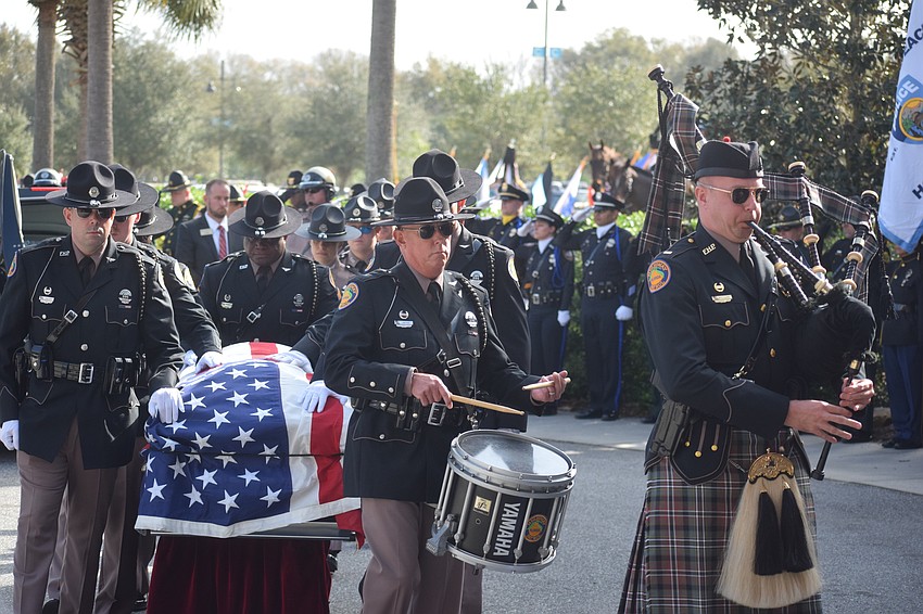 A bagpiper and a drummer lead the coffin of Trooper Joseph Bullock into Bayside Community Church.
