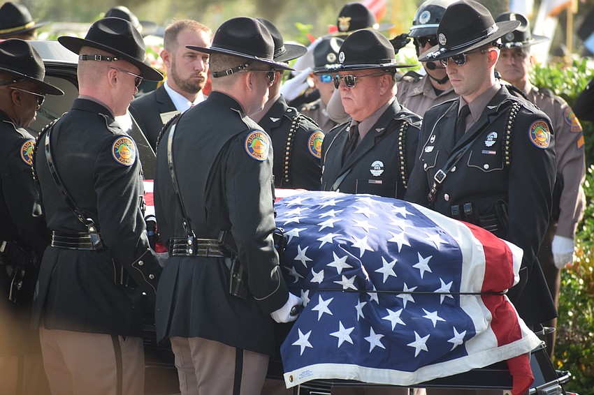 Pall bearers lift the coffin of Trooper Joseph Bullock off the hearse in front of Bayside Community Church in Lakewood Ranch.
