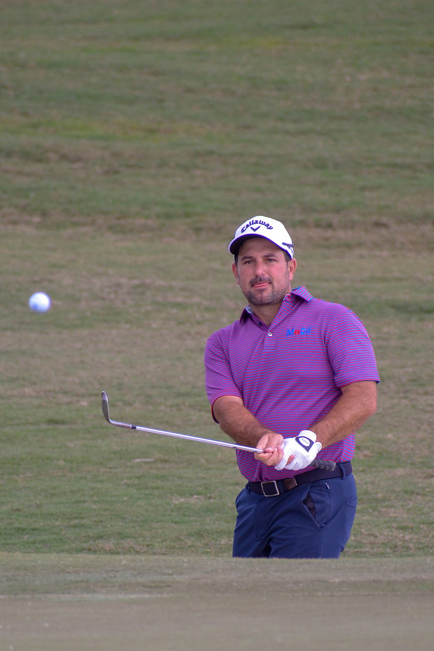 Roberto Diaz chips a ball onto the green of Lakewood National's No. 18 hole. Diaz finished one under par on the first day of the LECOM Suncoast Classic.