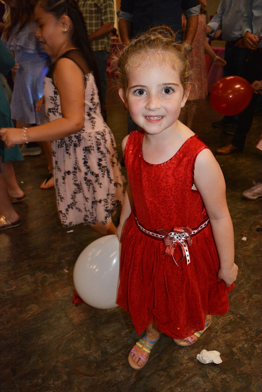 Kindergartner Lia Goldberg takes a break from dancing to chase balloons with friends.