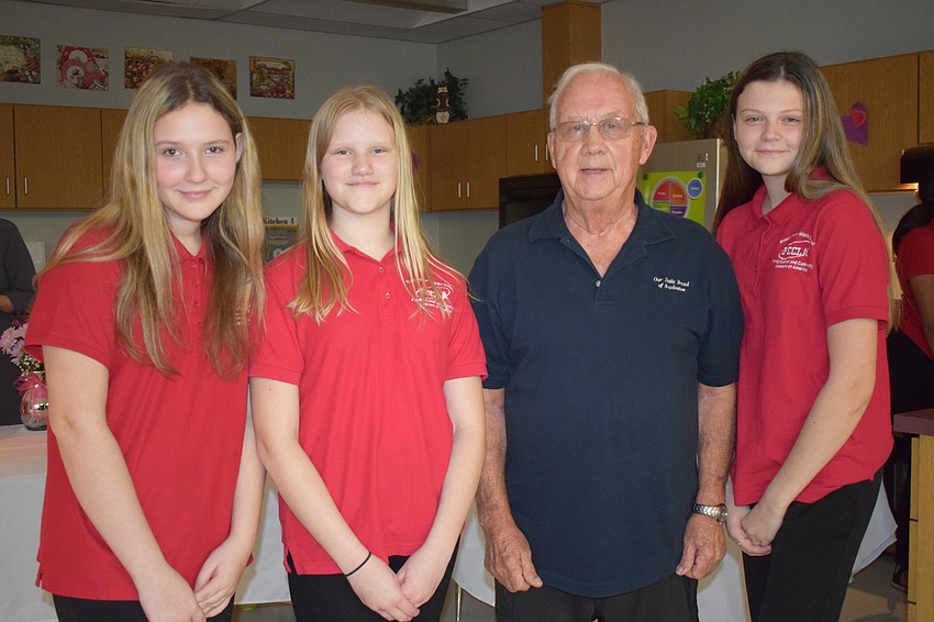 Eighth graders Katelyn White and Makenna Bradley, Our Daily Bread treasurer Robert Eikill and eighth grader Olivia Christman celebrate the donation from the Family Career and Community Leaders of America to Our Daily Bread.