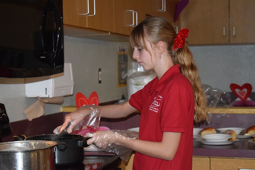 Skylar Armstrong, a seventh grader, stirs a pot of chicken gnocchi. 