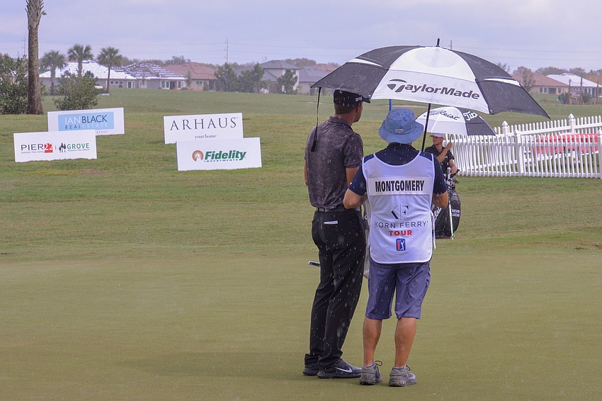 Taylor Montgomery chats with his caddie in the rain at the LECOM Suncoast Classic.