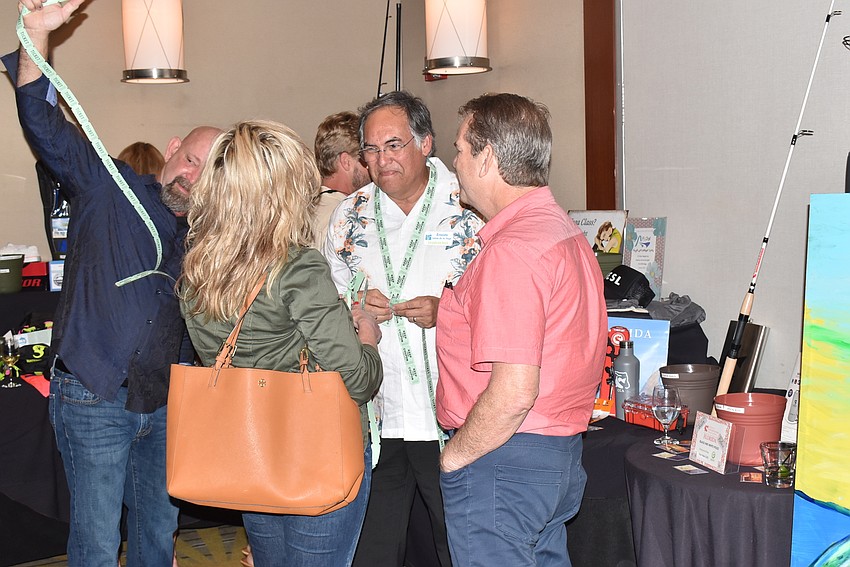 Attendees discuss the auction items