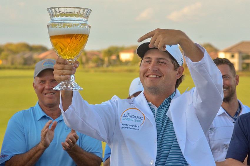 Andrew Novak relishes in victory while pointing at the beer-filled LECOM Suncoast Classic trophy.