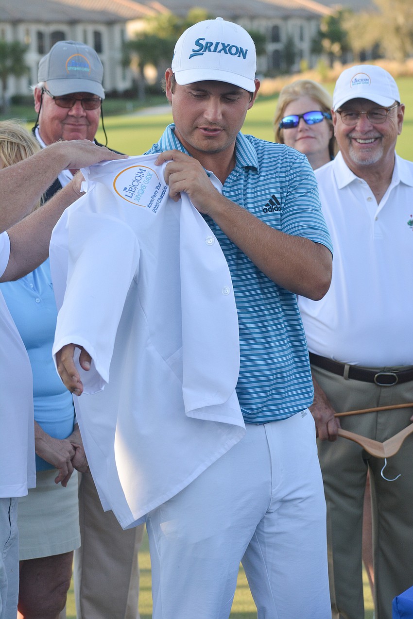 Andrew Novak puts on the honorary white dental jacket after winning the 2020 LECOM Suncoast Classic.
