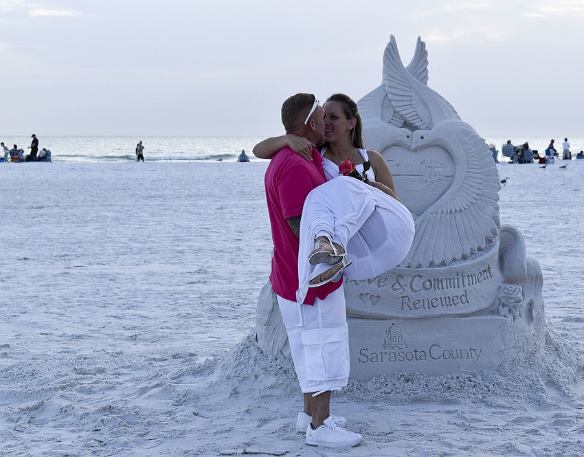 Kenny Passino lifts his wife Lindsey up for a kiss.