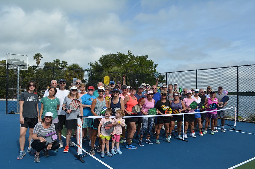 People who stayed until the end of open play pose on one of the newly completed pickleball courts Wednesday.