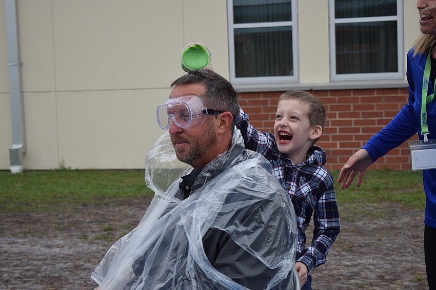 Principal Todd Richardson anticipates his first slime from kindergartner Elijah Predgen.
