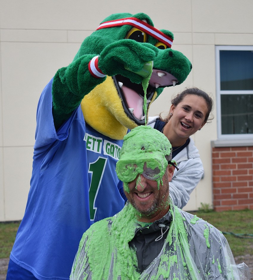 Chompy, the school's mascot, has his turn at sliming Principal Todd Richardson while Nicole Durbal, a PTO member watches.
