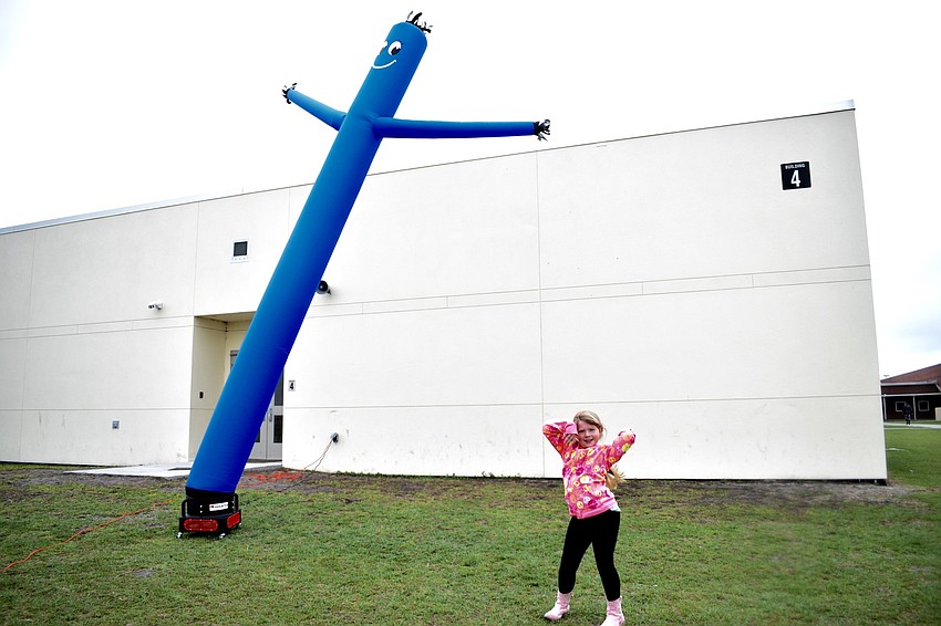 First grader Ariana Henderson tries to imitate an inflatable tube man.