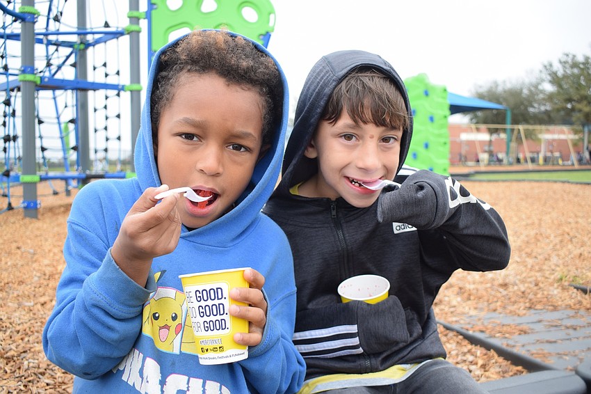 First graders Tavion Grate and Isaac Serrano try to enjoy their cherry Kona Ices in the cold weather.
