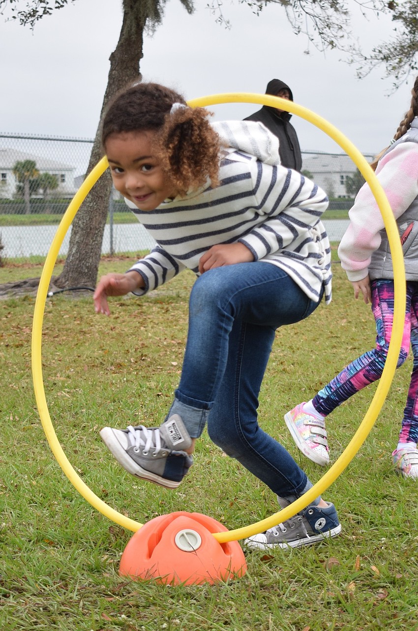 First grader Jaden McQueen walks through a Hula Hoop. 
