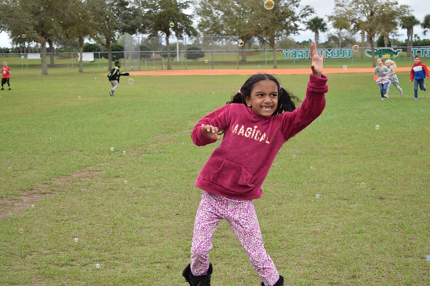 Kaitlyn Persaud, a first grader, tries to pop bubbles. 