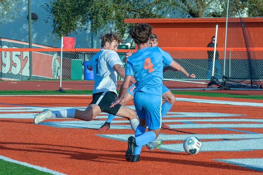 Junior forward Timothy Sheredy (7) storms the Boone defensive box, past Boone sophomore Sam Rogers (4).