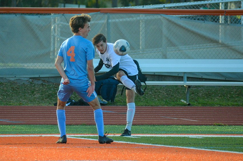 Aiden Holzborn fires a cross to the middle of the field, past Boone's Sam Rogers.