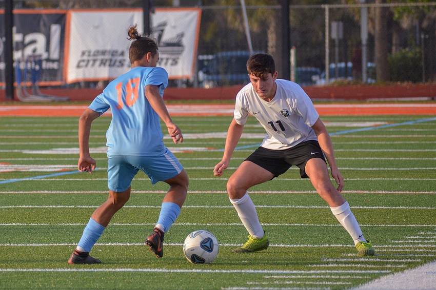 Senior forward Gio Christiano (11) guards Boone's Juan Gomez.