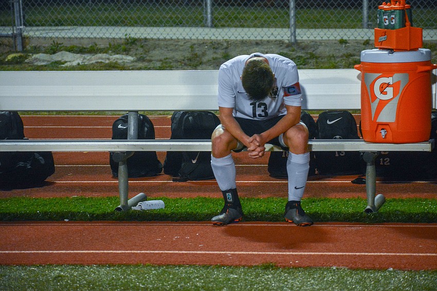 Mustangs senior defender Cade Schwarz sits on the team bench after the loss.
