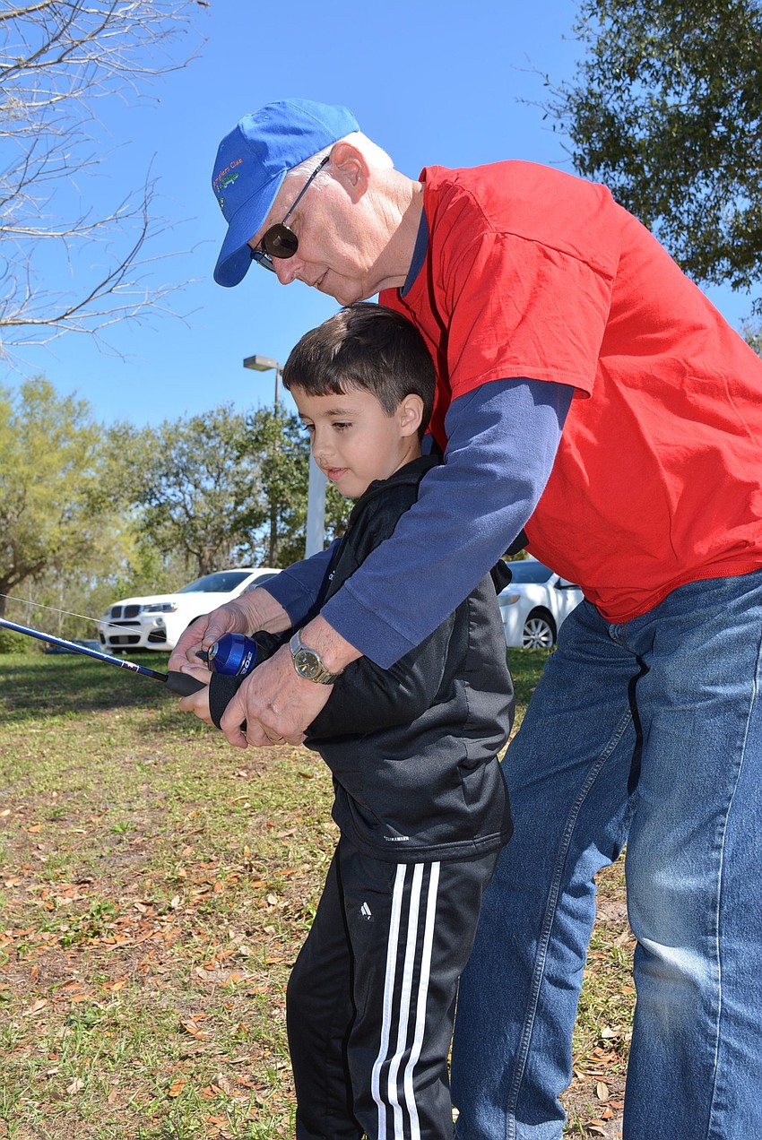 Eight-year-old East County resident Tobias Guillermoni gets help with casting from Anglers Club member Mark Staddler.