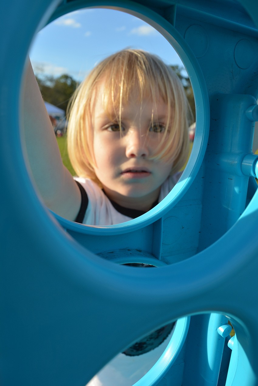 Four-year-old Alexander Ade, of Lakewood Ranch,  plays with a giant Connect 4 game before the sun sets.
