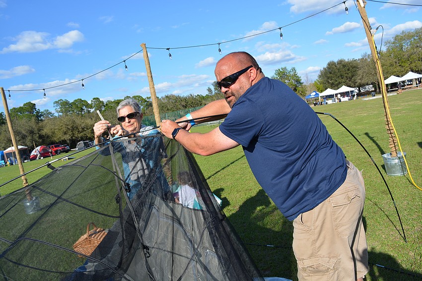 East County's Ines Vogler helps friend Paul Olah, of Greenbrook, set up his tent.