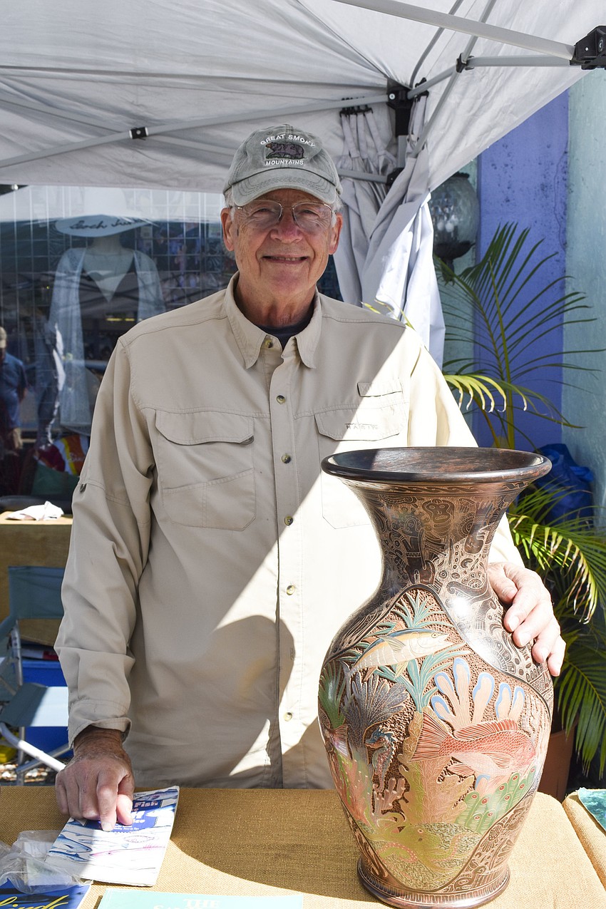 Ray Bulter poses with one of Emmanuel Maldonado's sculptures.