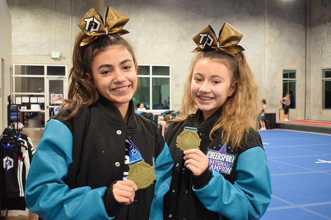Brooke and Hayley Obando show off their national championship jackets and medals.
