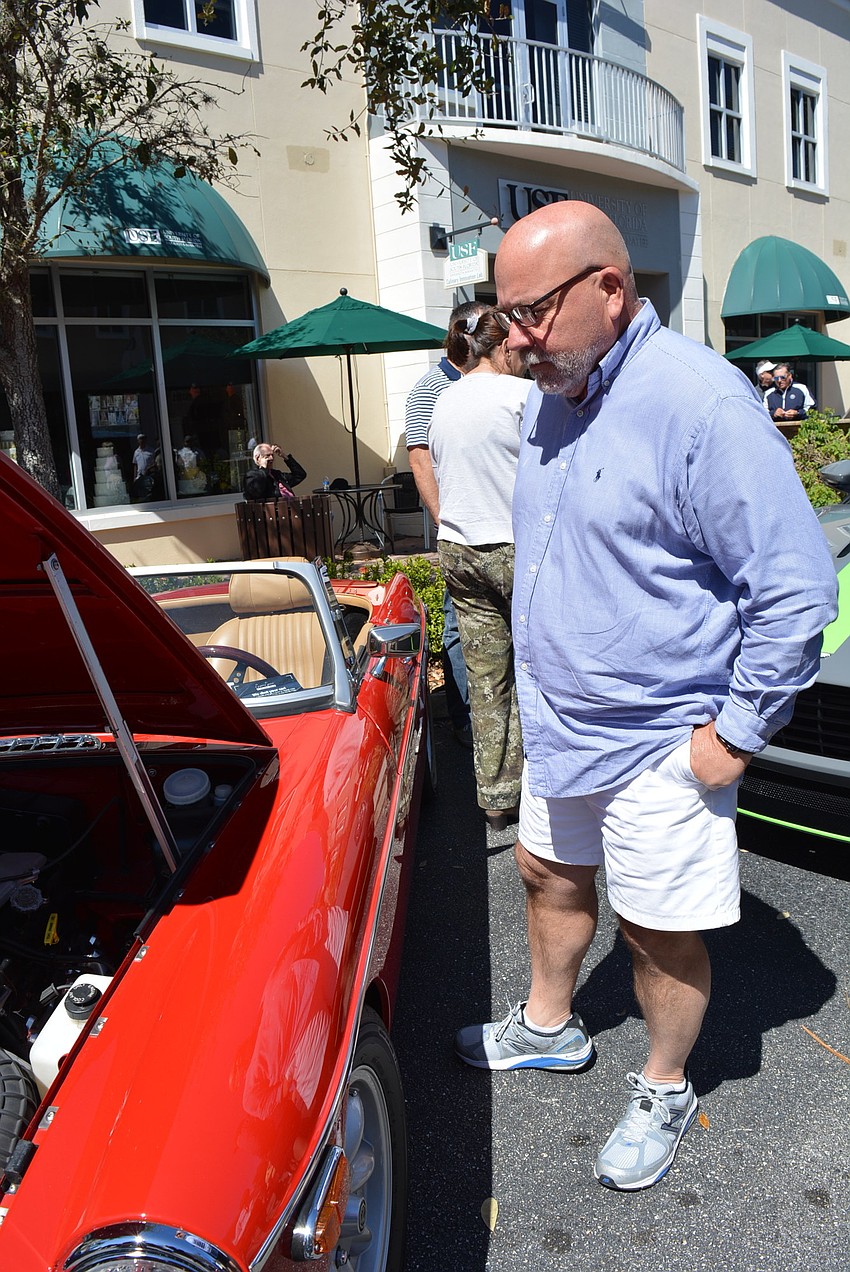 Oyster Bay's Alex Forsyth checks out a 1974 MGB. He says the blue Ferrari he saw was his favorite of the show.