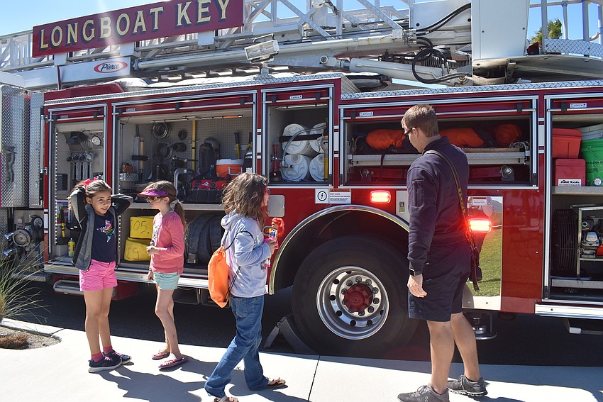 Zuleika Zunz and Alahna and Lexie Smith check out the fire truck with guidance from David Oliger.
