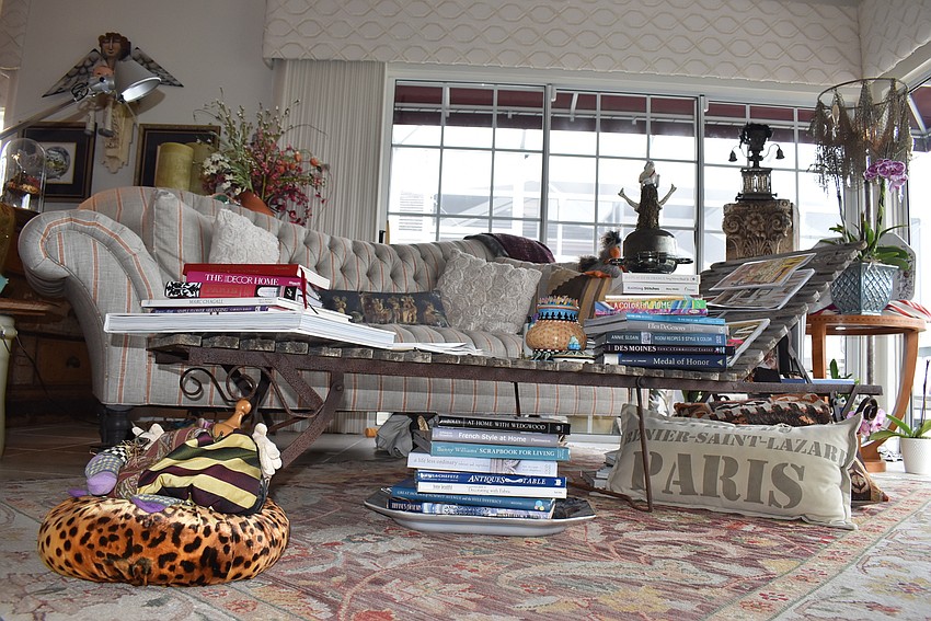 In the sitting room, a lounge chair is draped with magazines.