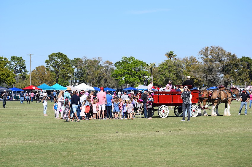 Children line up at halftime to ride a wagon pulled by the famous Clydesdales.
