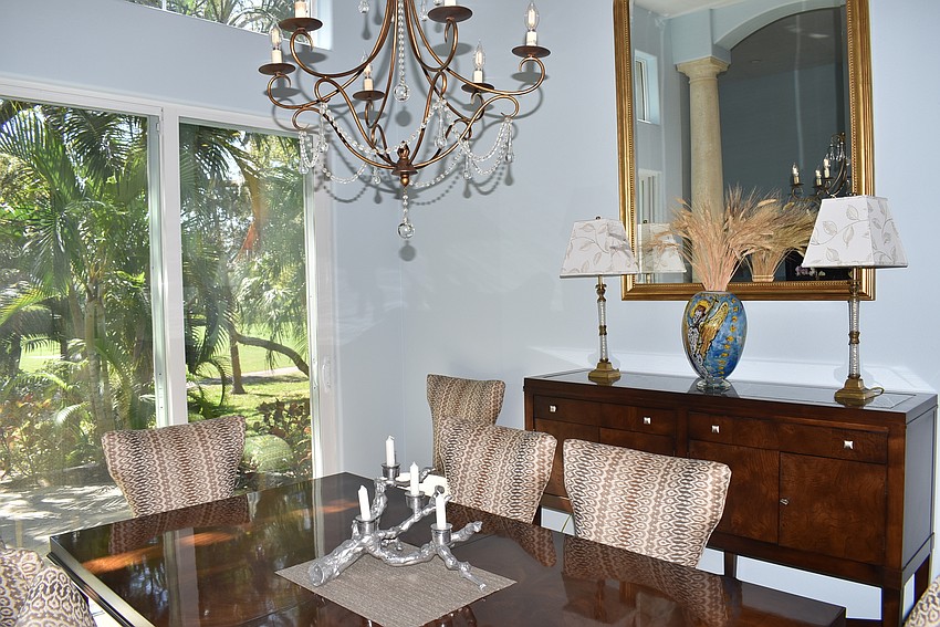 The dining room's dark pieces contrast the light in the house.