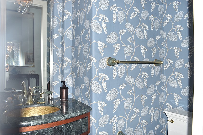 The bathroom's blue wallpaper provides a calming environment.